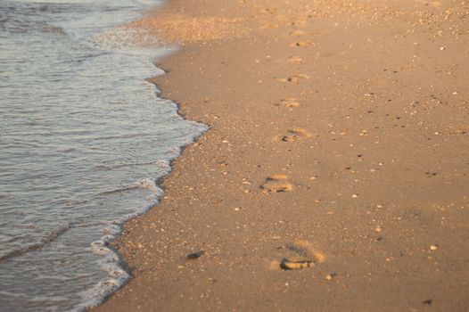 Footsteps on the beach by the sea in summer