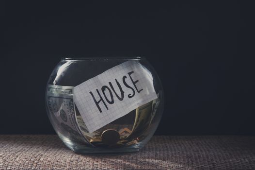 Savings money jar with coins for a house