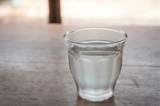 Drinking water in a glass on wooden table, stock photo