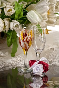 Wineglasses and flowers on a glass background
