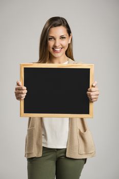 Beautiful and happy woman holding a chalkboard, with copy-space