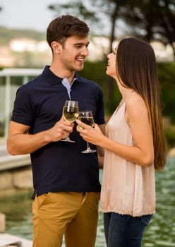 Young couple tasting wine near by the pool on a hotel