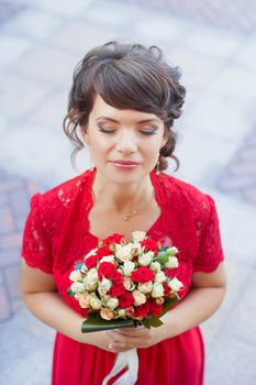 Girl in evening red dress in a warm summer day