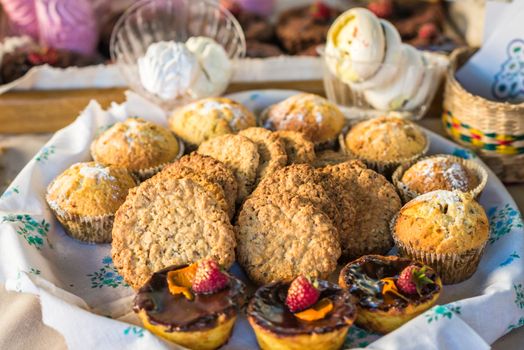 Oatmeal cookies and delicious cupcakes on a white tablecloth