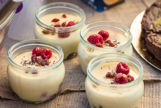 Delicious yogurt in jars with raspberries and raisins