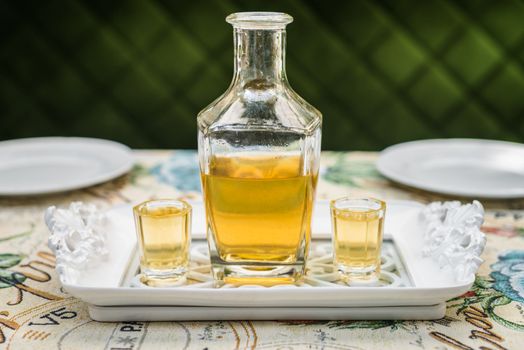Carafe with honey vodka on white elegant tray