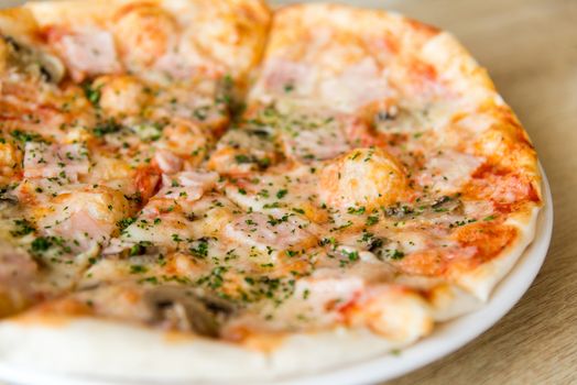 Pizza with mushrooms and ham on a plate