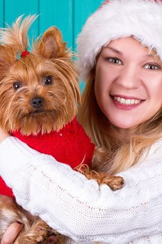 Beautiful girl in santa cap with yorkie dog in red sweater