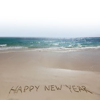 Happy new year handwriting on tropical sea beach
