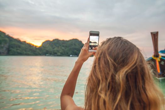 Woman taking photos with smartphone in Thailand