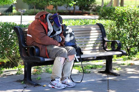 San Francisco, CA, USA - September 26, 2013: Homeless man sleeps on the street in the center of San Francisco