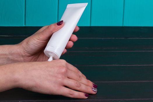 Female hand cream squeeze out of a tube