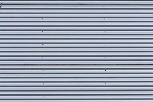 Silver-colored metal wall corrugated sheet metal background.