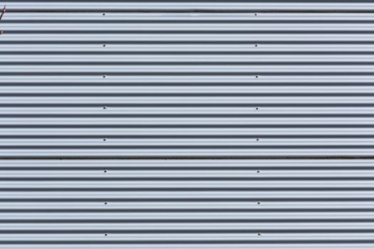 Silver-colored metal wall corrugated sheet metal background.