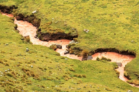 Brown river meandering in the peruvian andes, it takes his colores because of the minerals and the sediments