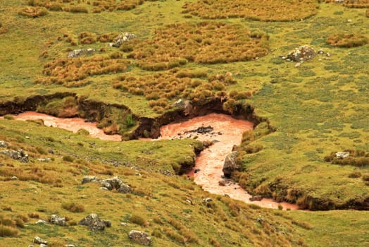 Brown river meandering in the peruvian andes, it takes his colores because of the minerals and the sediments