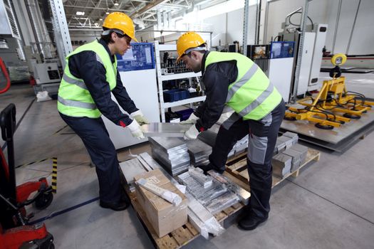 Workers taking aluminium billet at CNC machine shop