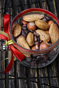 Glass Christmas jar with hazelnuts,almonds and nuts