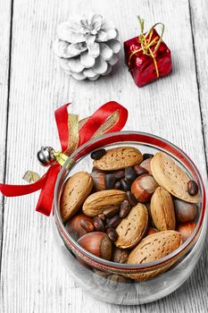 Glass Christmas jar with hazelnuts,almonds and nuts