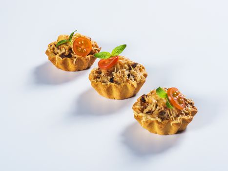 Tartlet with mushrooms and cheese on light background