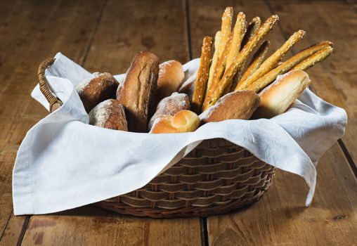Bread  in old wicker basket on wooden background