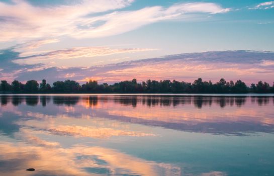 Colorful morning sunrise reflected in mirror clear lake waters