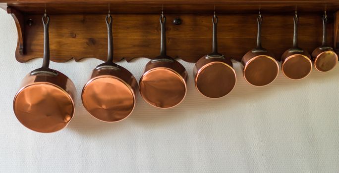 set of saucepans hanging from a rack in the kitchen