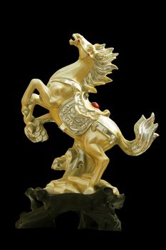 Image of golden horse statue on black background.