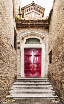 Old Italian red front door in Urbino, Italy