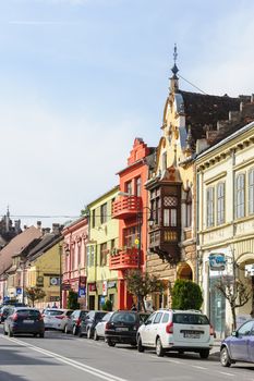 Sighisoara, Romania - October 19th, 2016: View of modern streets with people and cars of medieval Sighisoara, Transylvania region, Romania