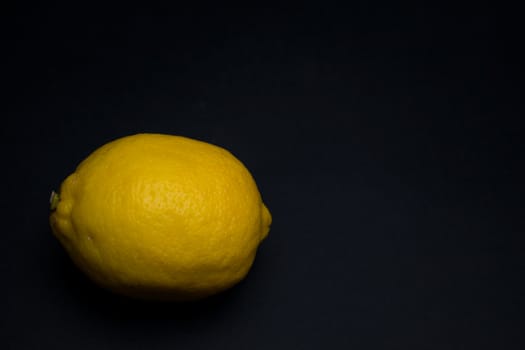 Raw entirre isolated lemon on a dark background