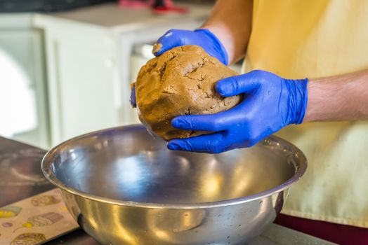 Hand knead dough with gloves in a bowl. Preparing cakes