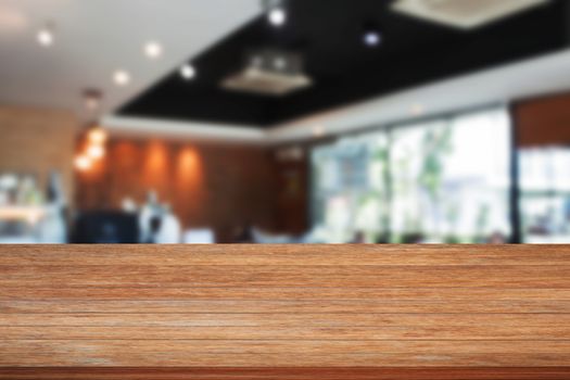 Top of wooden table with blurred cafe interior for background. product display template