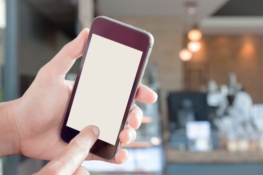 Womanan using smartphone with blurred coffee shop, stock photo