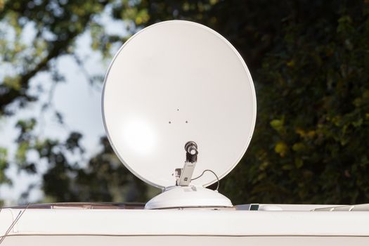 Satellite dish with sky on roof of camper van