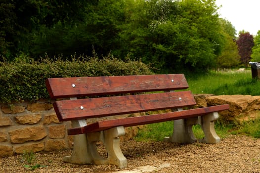 Bench in lamellas of brown wood in a wooden corner.