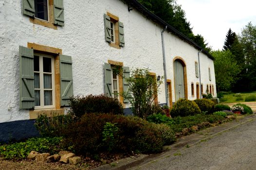 Old farm with a facade in thatch of white color and the flower and plants.