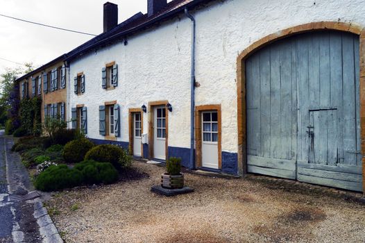 Old farm with a facade in thatch of white color and the flower and plants.