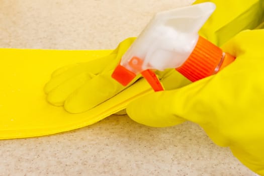 Hand in rubber glove cleans a new kitchen. Woman with housework, cleaning the kitchen.
