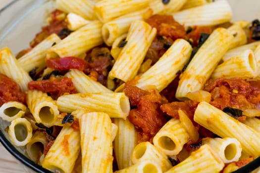 Close-up image of cooked tortiglioni pasta with tomato sauce