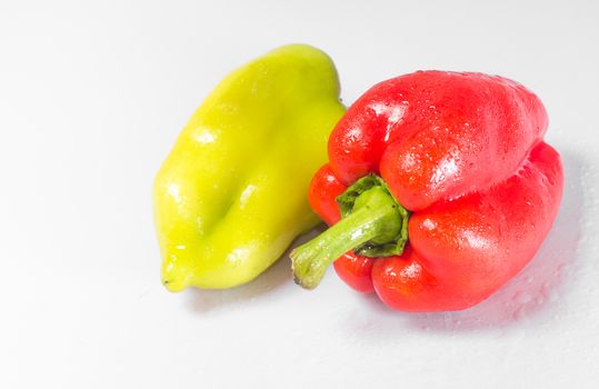 Two peppers green and red on a white background. Front and back