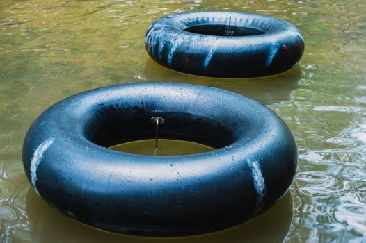 Old inner tubes floating on a river, selective focus