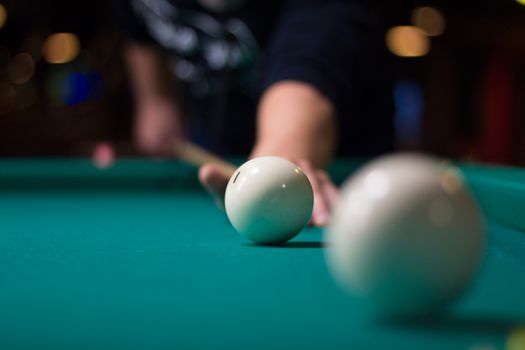 Russian billiards game in progress: player aims to shoot balls with cue