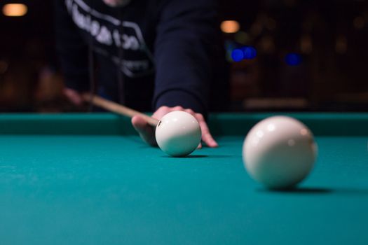 Russian billiards game in progress: player aims to shoot balls with cue