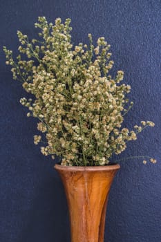 White cutter flower in wooden vase on gray background