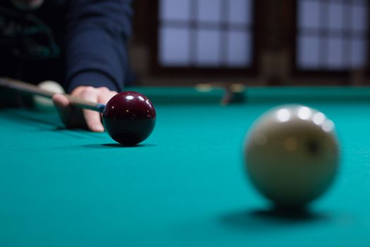 Russian billiards game in progress: player aims to shoot balls with cue