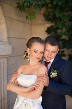 Stylish newlyweds tenderly embraced posing in the photo