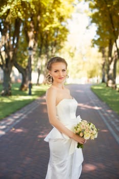 The bride with a bouquet on a walk in the park