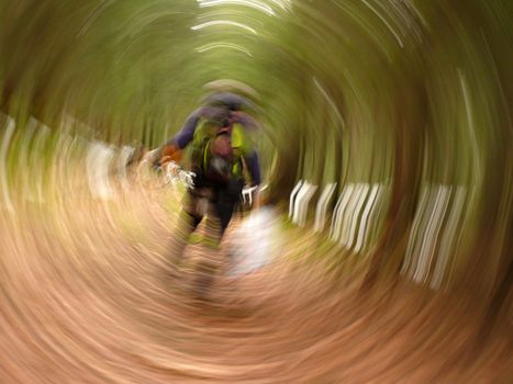abstract Photo out of focus roundabout. man with backpack in forest. Can be used as background