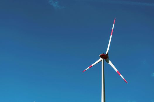 Wind power turbine generating electricity on blue sky